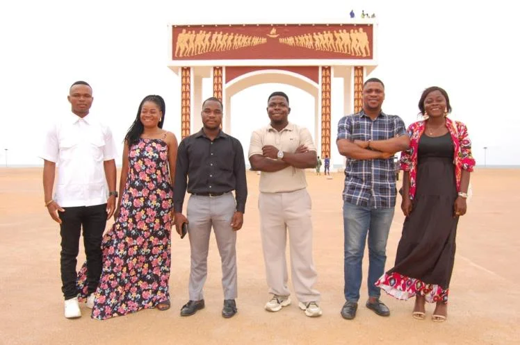 Six membres de l'équipe JDA posant devant un monument